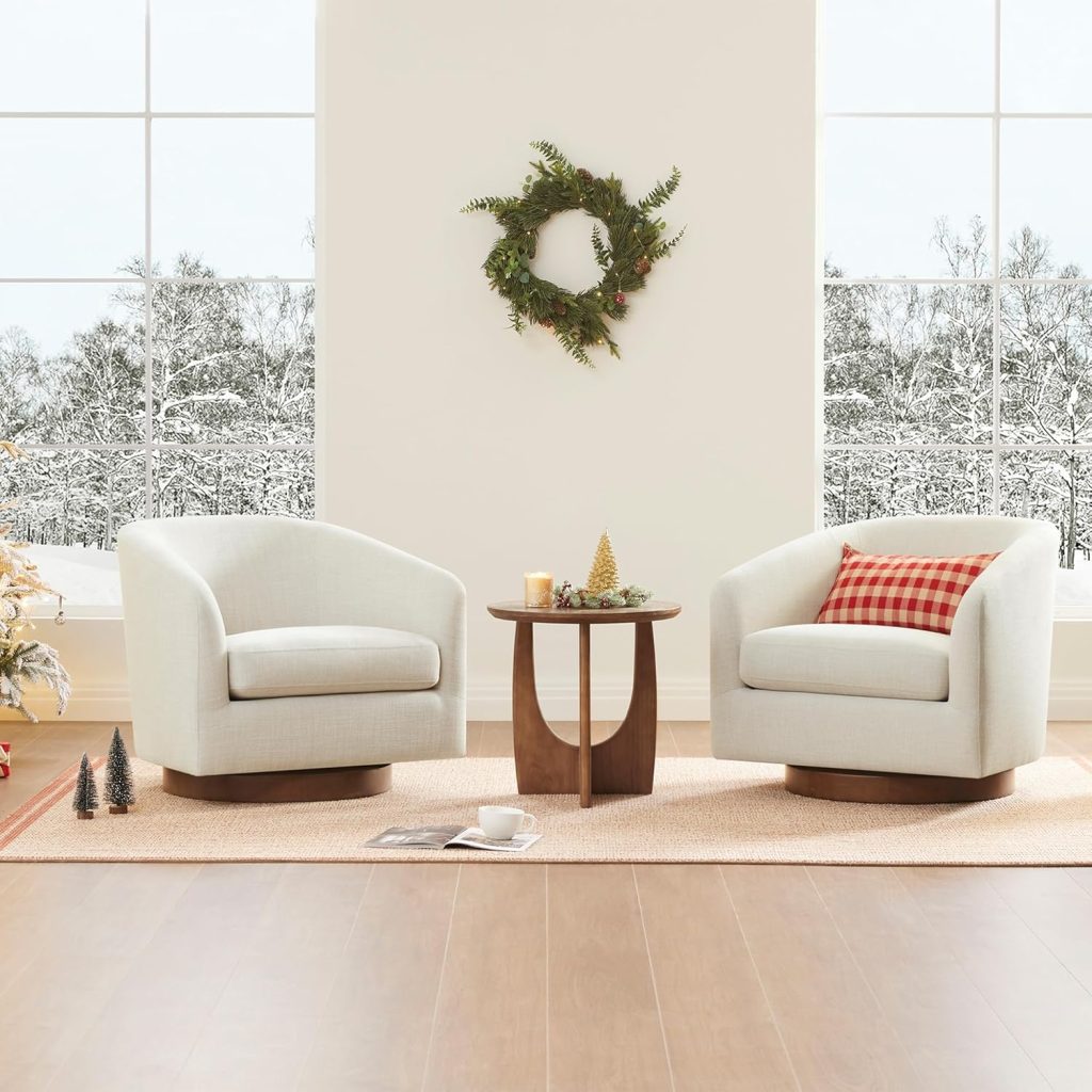 Pair of CHITA linen swivel barrel accent chairs facing each other across a small round wood side table in a bright living room