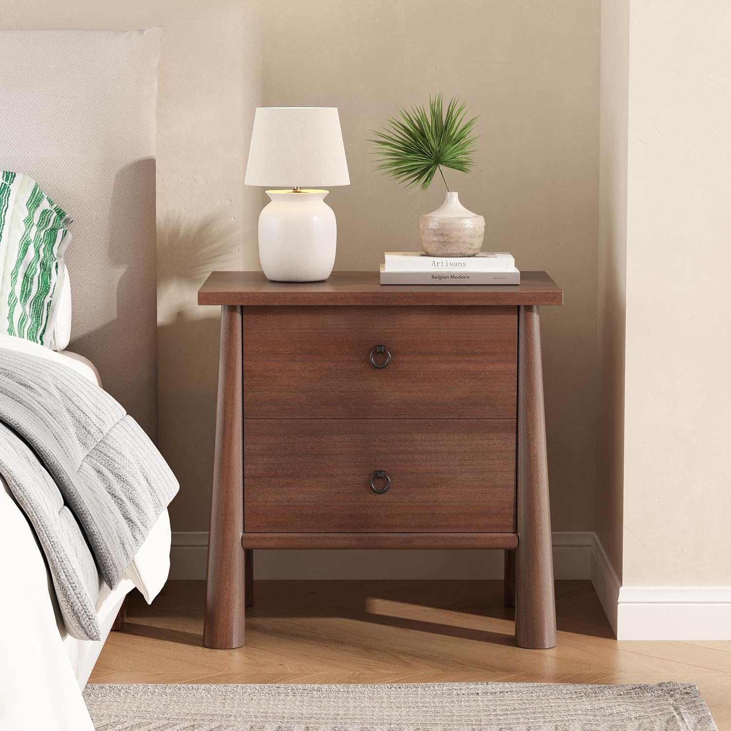 Christopher Knight Home Logan mid century modern nightstand in brown wood with two drawers and rounded tapered legs beside a bed