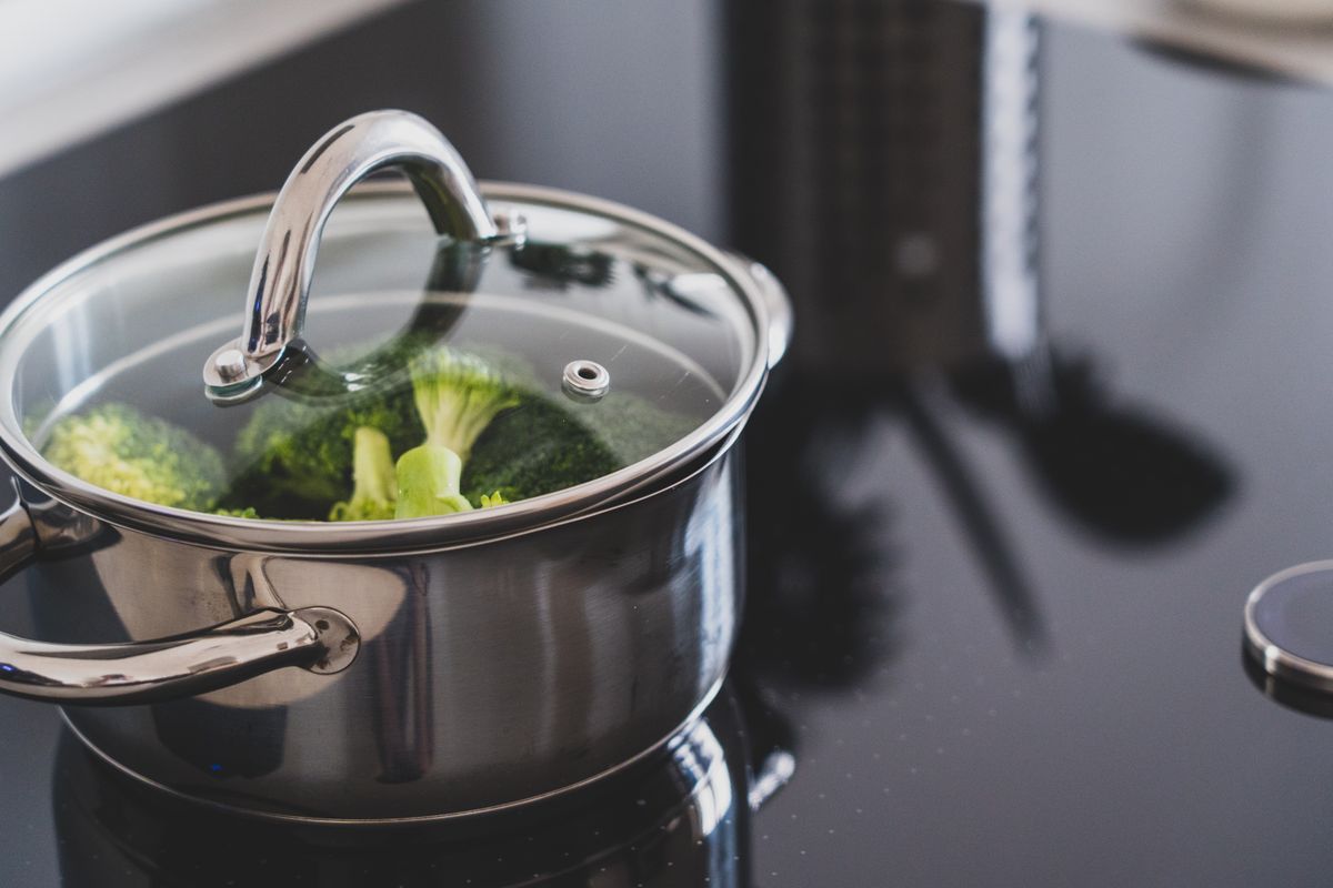 Two electric pressure cookers side by side on a kitchen counter