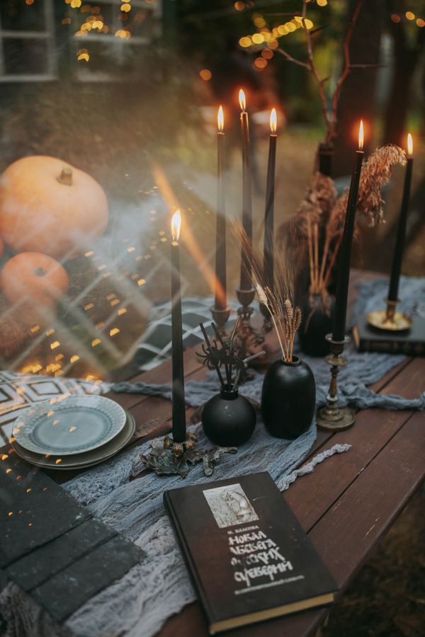 Dining table decorated for Halloween with pumpkins and candles