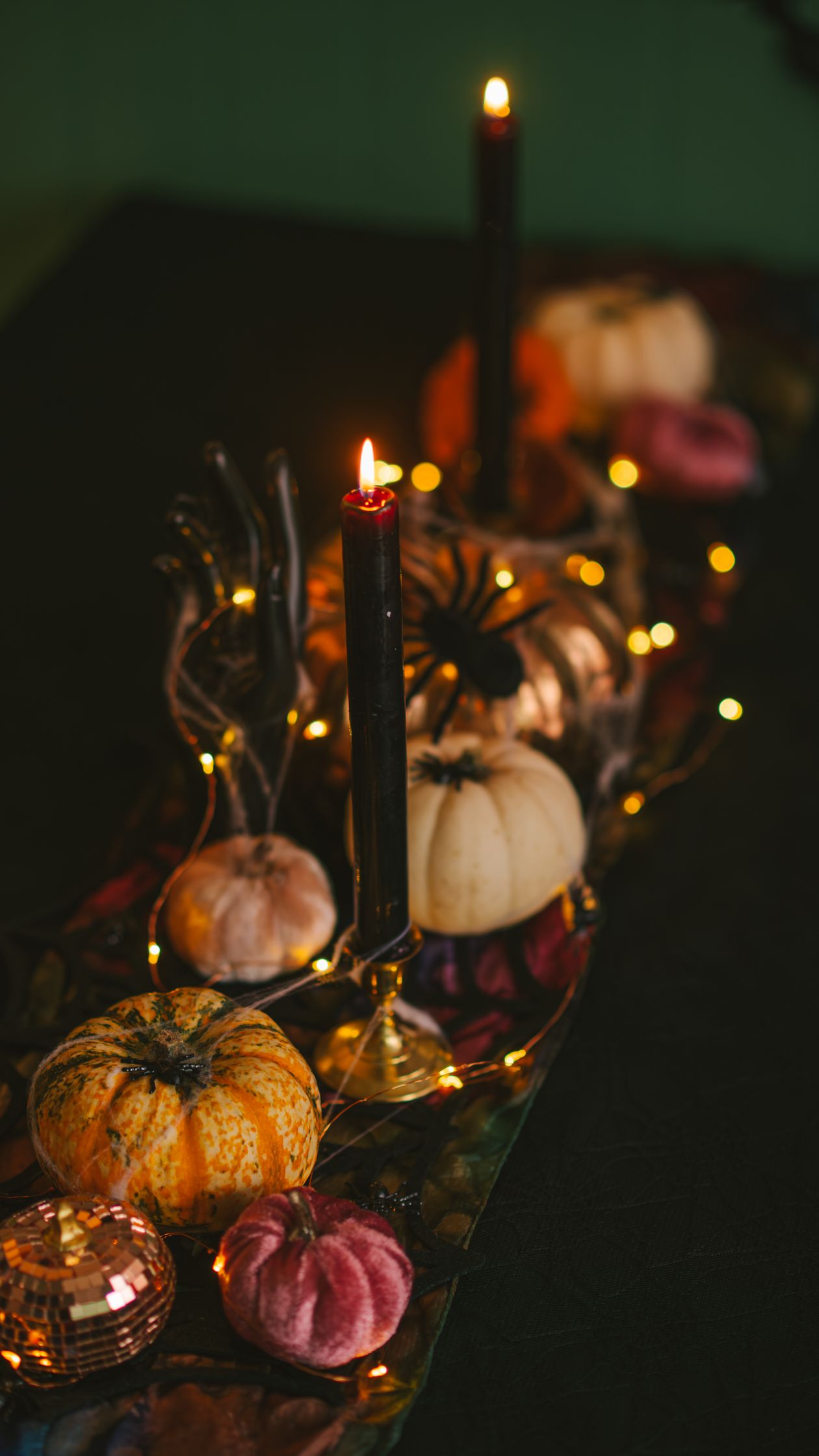 Halloween mantel decor styling with black candles, mini pumpkins and fairy lights