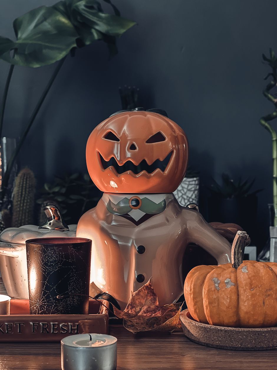 Ceramic jack-o-lantern with candles and pumpkins for halloween mantel decor