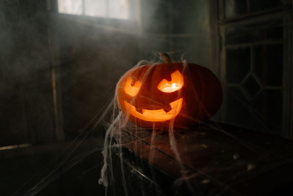 Halloween mantel decor idea with glowing jack-o-lantern and cobwebs