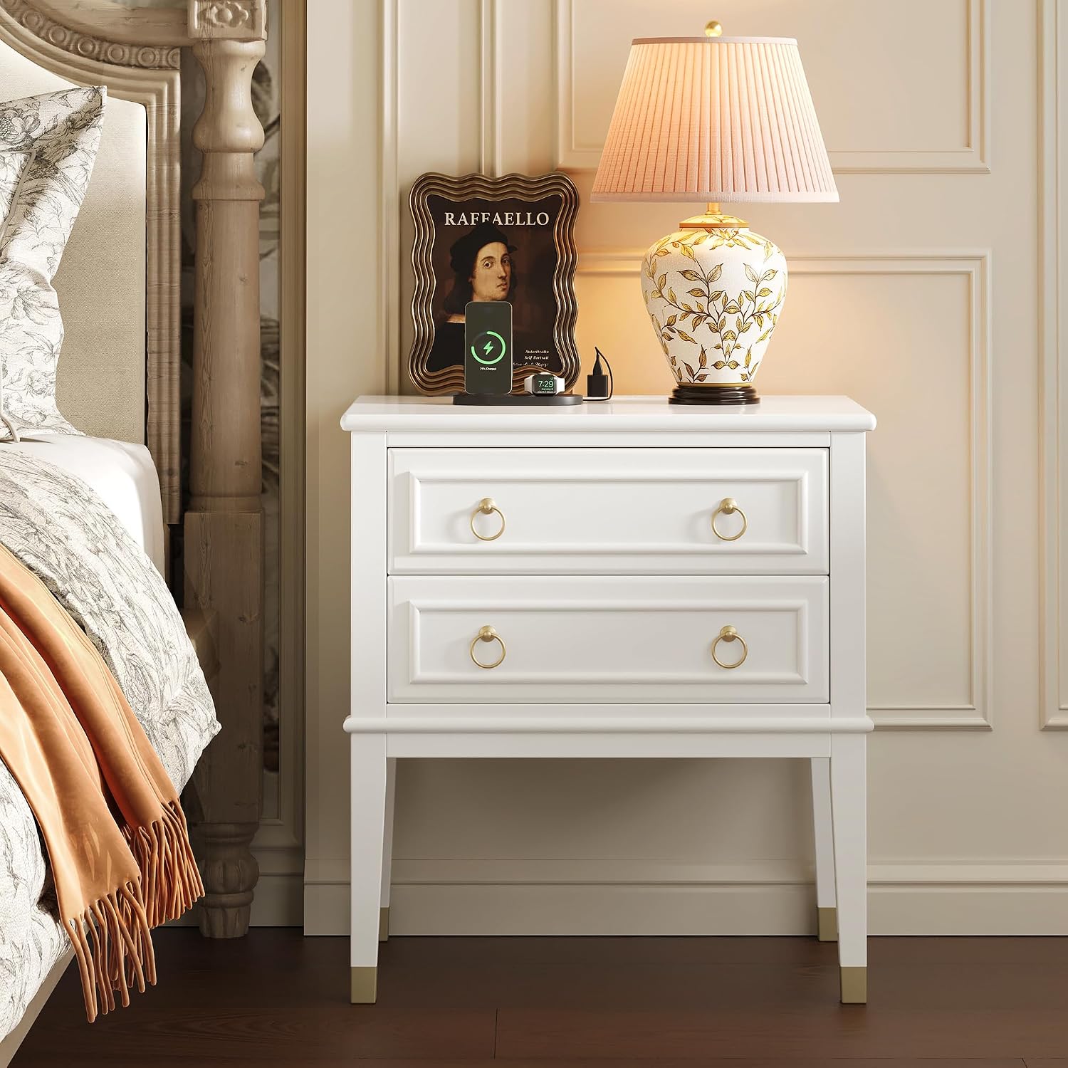 Huuger 27 inch tall white nightstand with two drawers and gold ring pulls beside a bed with a ceramic table lamp on top