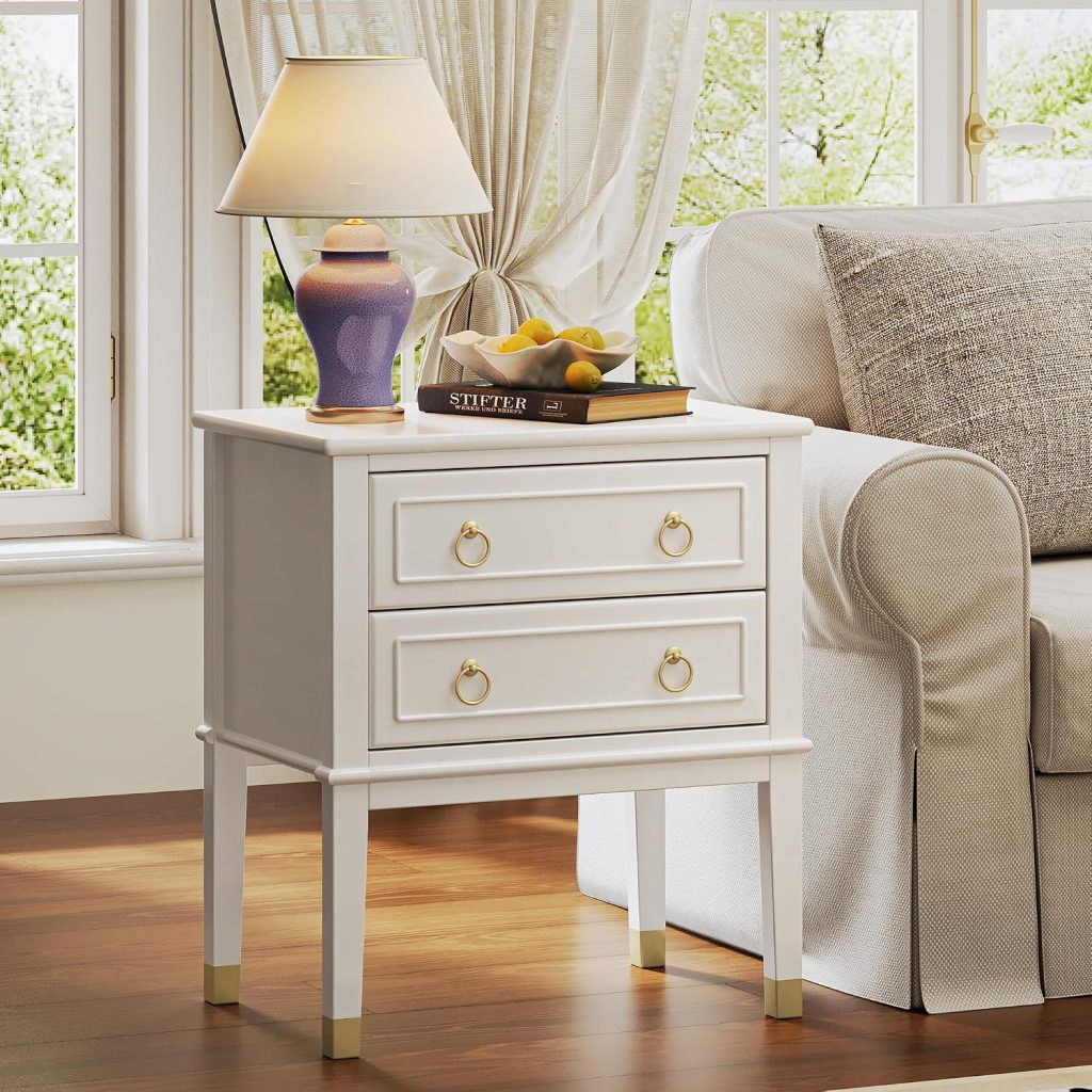 Huuger tall white two drawer nightstand used as a sofa side table with a ceramic lamp and book on top in a bright living room