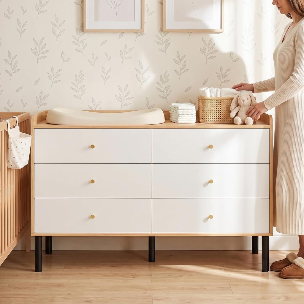 LYNSOM two-tone wood dresser with white drawers used as a nursery changing surface beside a crib