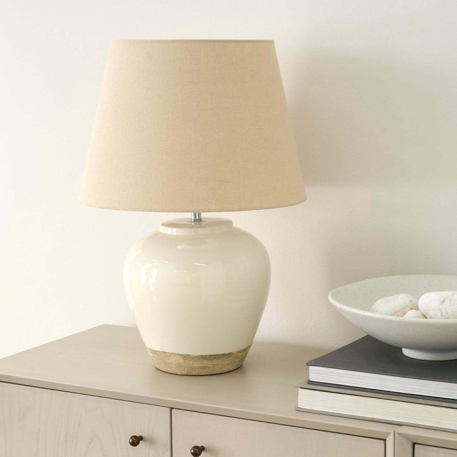 Nourison 20 inch two-tone ceramic table lamp with beige shade on a console table
