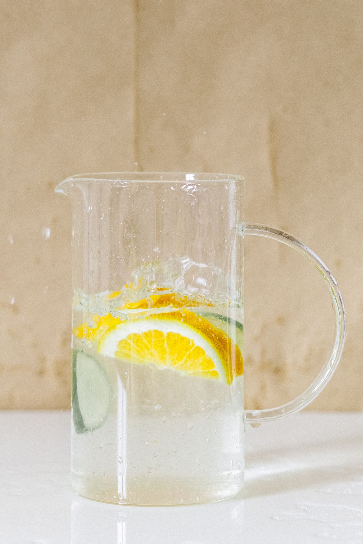 Water filter pitcher pouring fresh filtered water into a glass